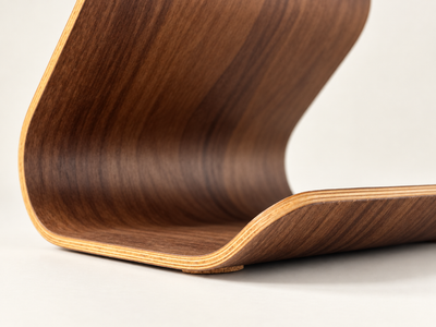 Close-up of the Ray tablet stand, showing a rich dark brown wood grain finish with layered light natural wood veneer edges on a clean white background.